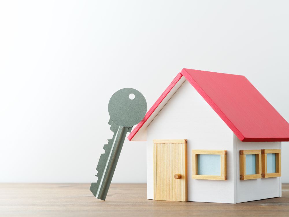 Casa em miniatura com chave ao lado, simbolizando como funciona o aluguel sem fiador de forma prática e acessível.