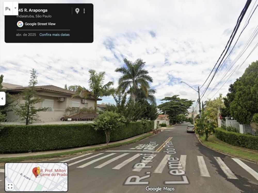 Vista de rua tranquila com casas de alto padrão e arborização, característica do bairro Vila Suíça Indaiatuba em área residencial consolidada.