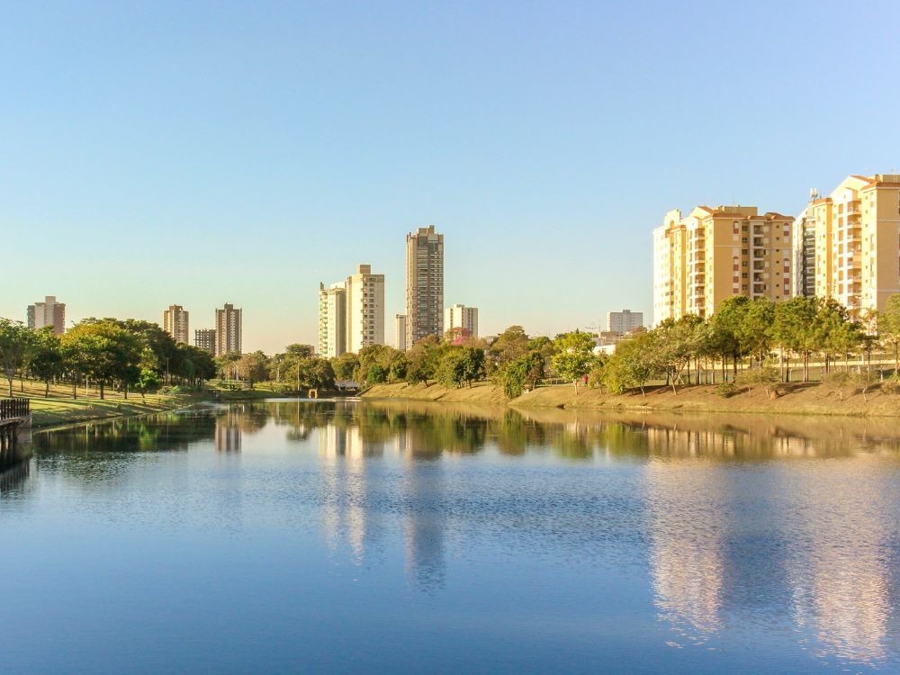Lago com prédios ao redor e paisagem urbana agradável, destacando passeios e o que fazer em Indaiatuba.