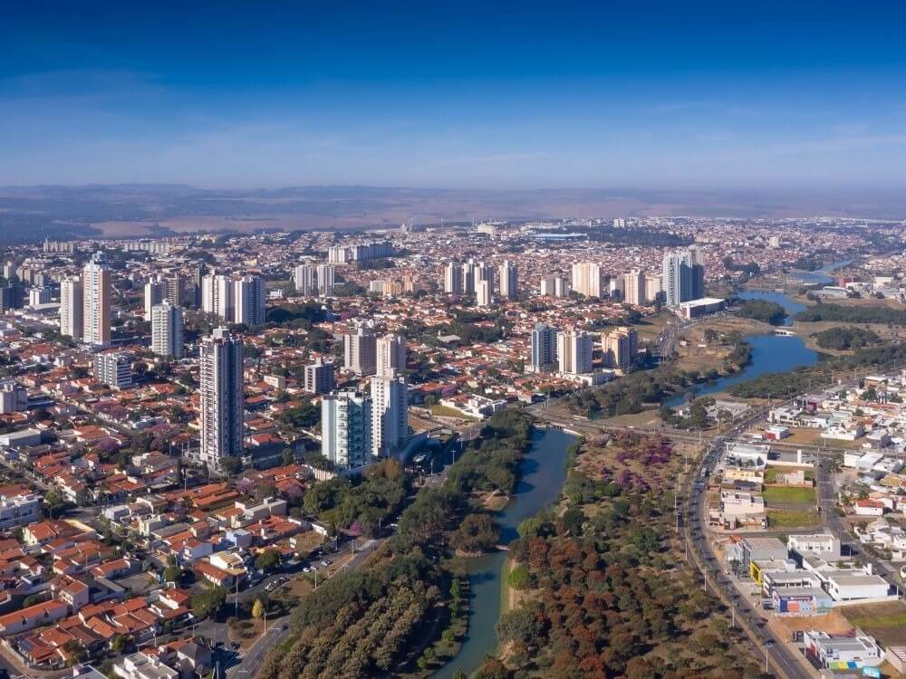 Vista aérea da cidade com rio e áreas urbanizadas, ilustrando pontos turísticos e o que fazer em Indaiatuba.