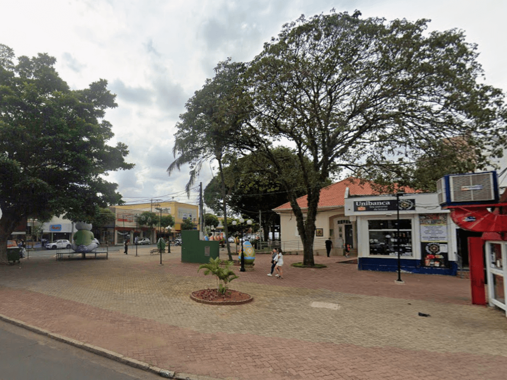 Praça Rui Barbosa no Centro de Indaiatuba, com árvores de grande porte, comércio ao redor e espaço para circulação de visitantes.