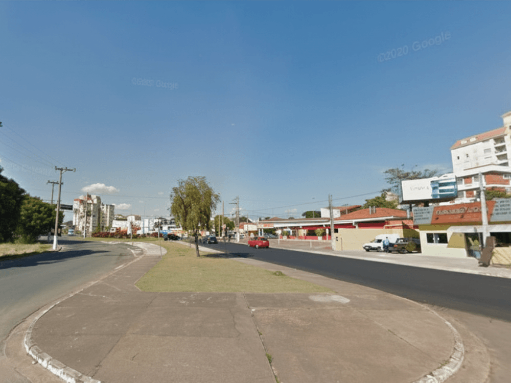 Vista da avenida de acesso ao Shopping Jaraguá Indaiatuba, com estabelecimentos comerciais e vias que facilitam a chegada ao local.