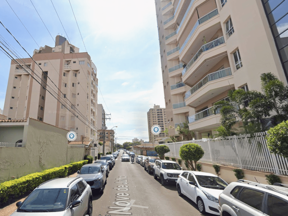 Edifícios residenciais em rua urbana com veículos estacionados, representando a verticalização e o perfil residencial do Centro de Indaiatuba.