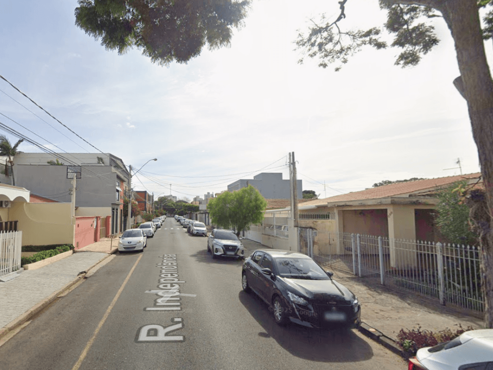 Rua residencial com casas, prédios baixos, árvores e carros estacionados, mostrando o perfil urbano de Indaiatuba. Tudo para demonstrar onde morar em Indaiatuba.