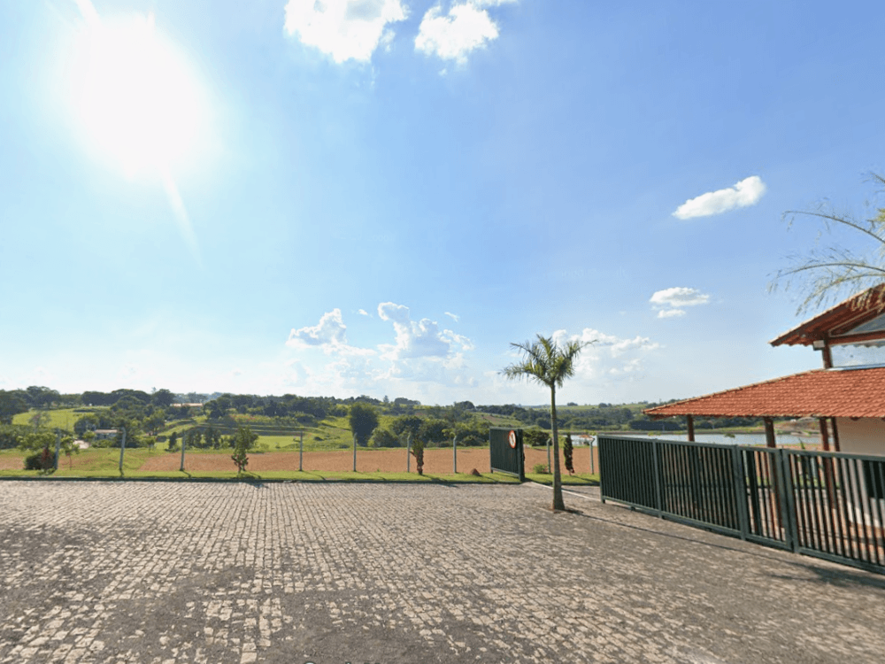 Área pavimentada com vista para paisagem verde e lago ao fundo, destacando um espaço de convivência em parques Indaiatuba.