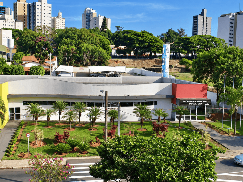 Prédio da Secretaria Municipal de Cultura de Indaiatuba cercado por jardins, árvores e edifícios residenciais.