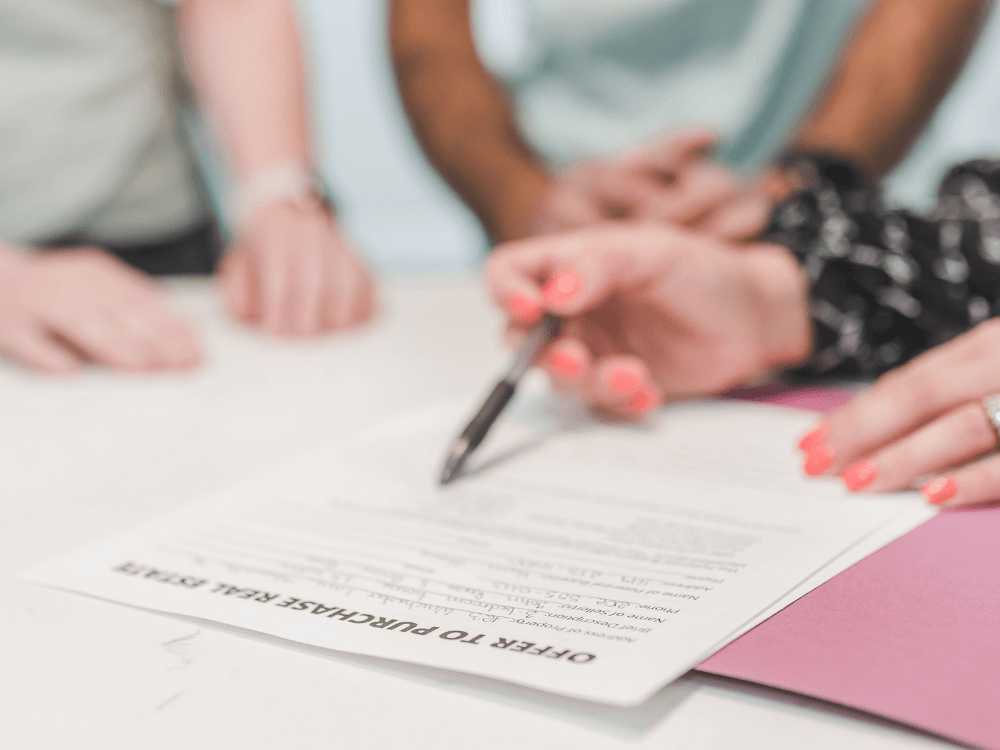 Pessoa assina um documento imobiliário sobre uma mesa, representando a formalização de uma transação sujeita ao ITBI Indaiatuba.